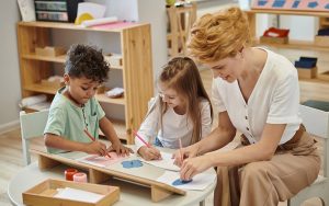 teacher and children drawing during lesson