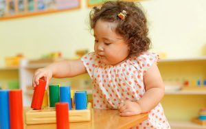 curly hair toddler playing at school