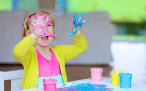 happy toddler playing with paint