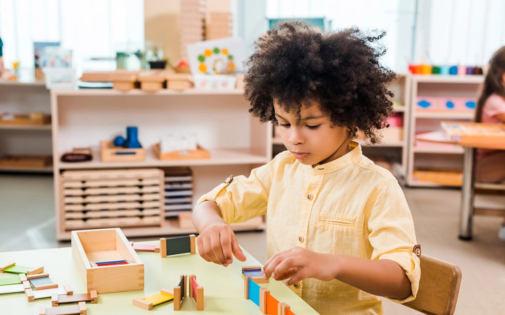 kid playing with blocks at school table