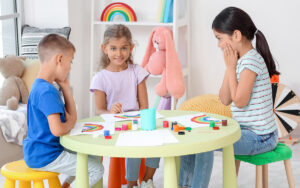 Little children painting rainbow at a classroom