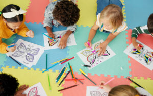 kids coloring on the floor in a classroom