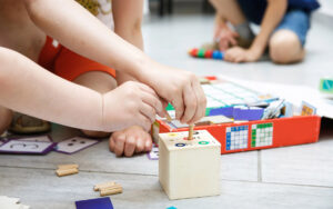 kids in classroom with wooden learning toys